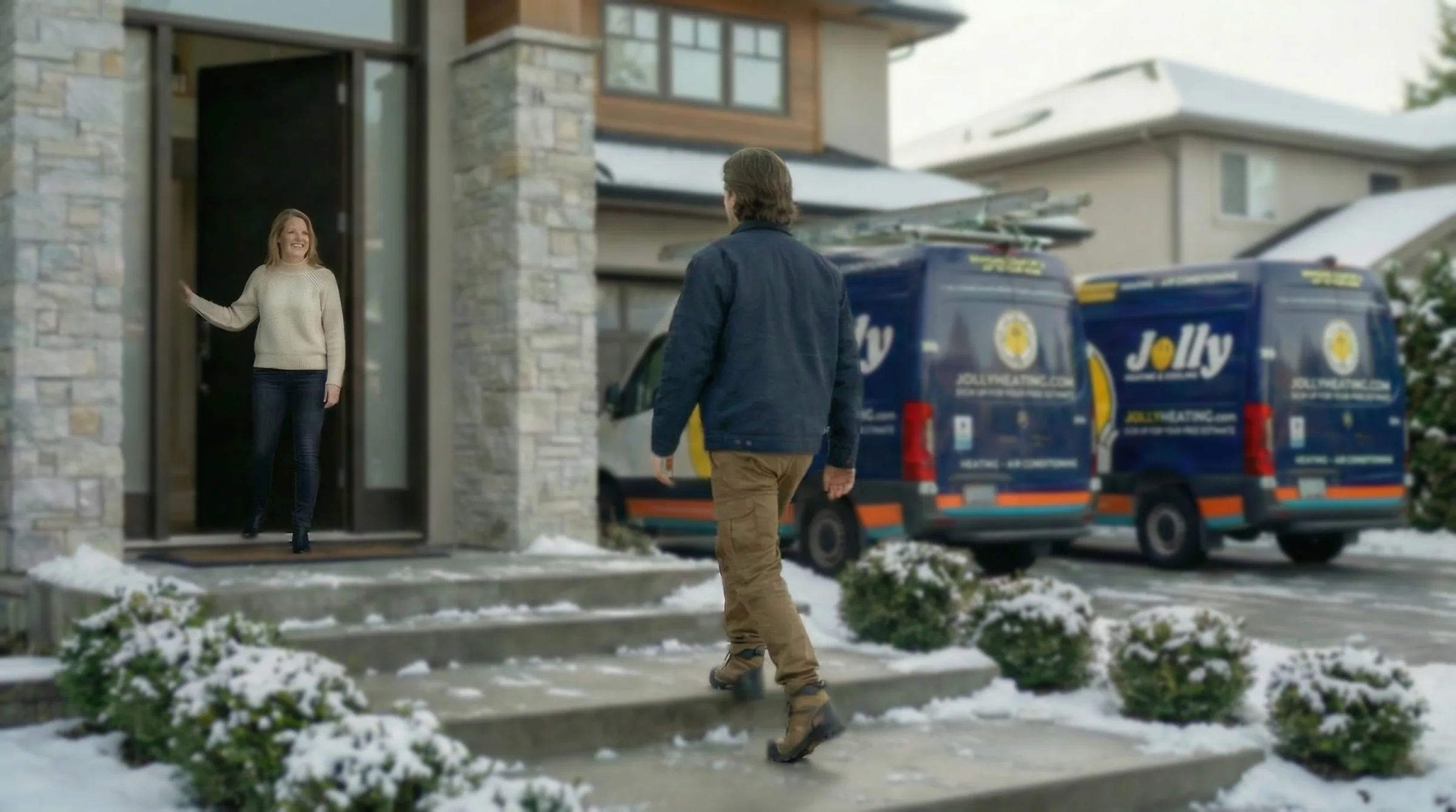 Jolly technician arriving at a home in winter as the homeowner opens the door